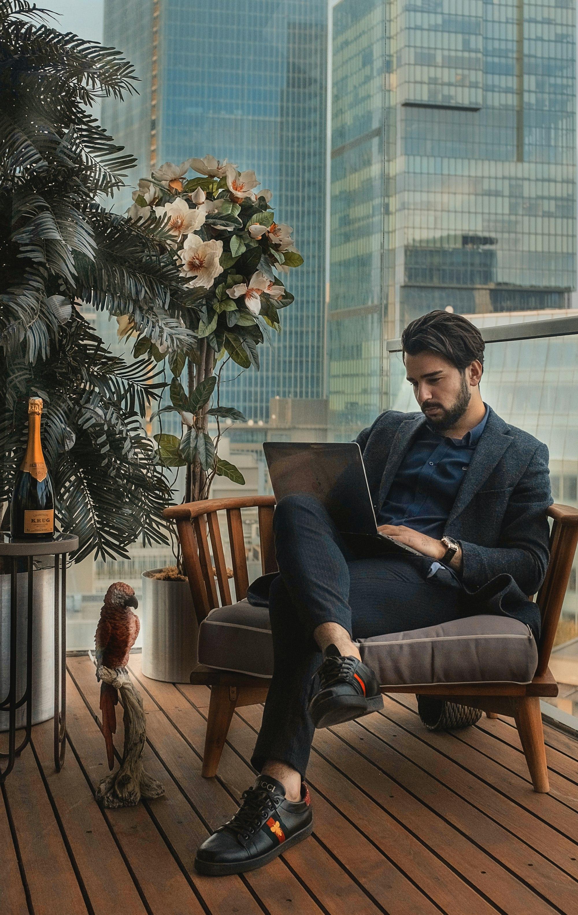 well-dressed man sitting at a table with an exotic bird and bottle of wine