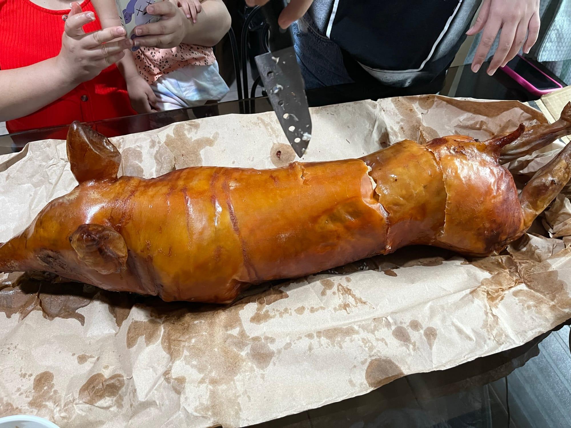 Crispy roasted pig being sliced for dinner