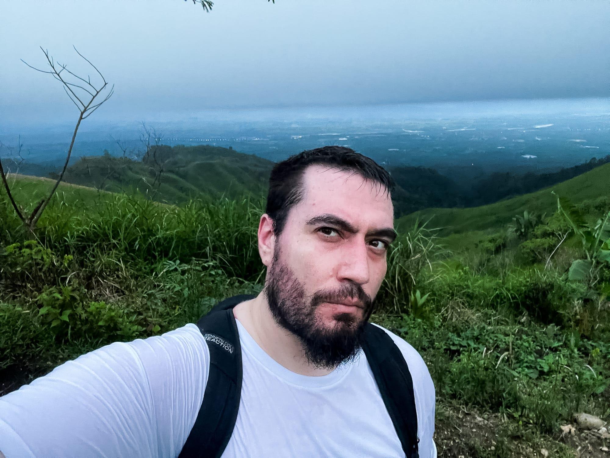 selfie of the author with a view of the city below the mountain in the background