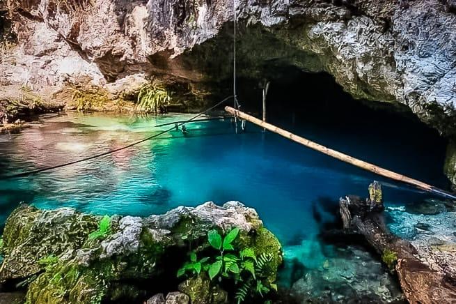 Blue lagoon spring with a cave behind it