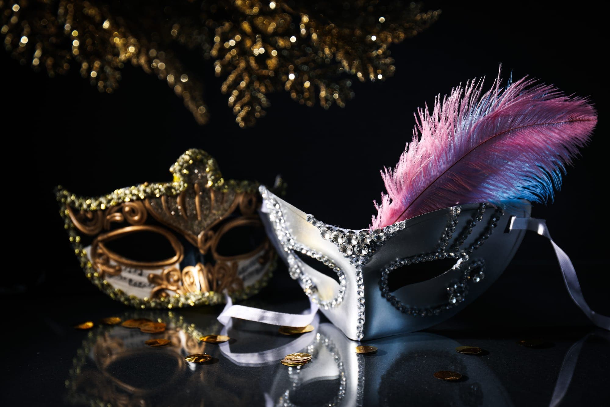 Two masquerade masks on a dark background.