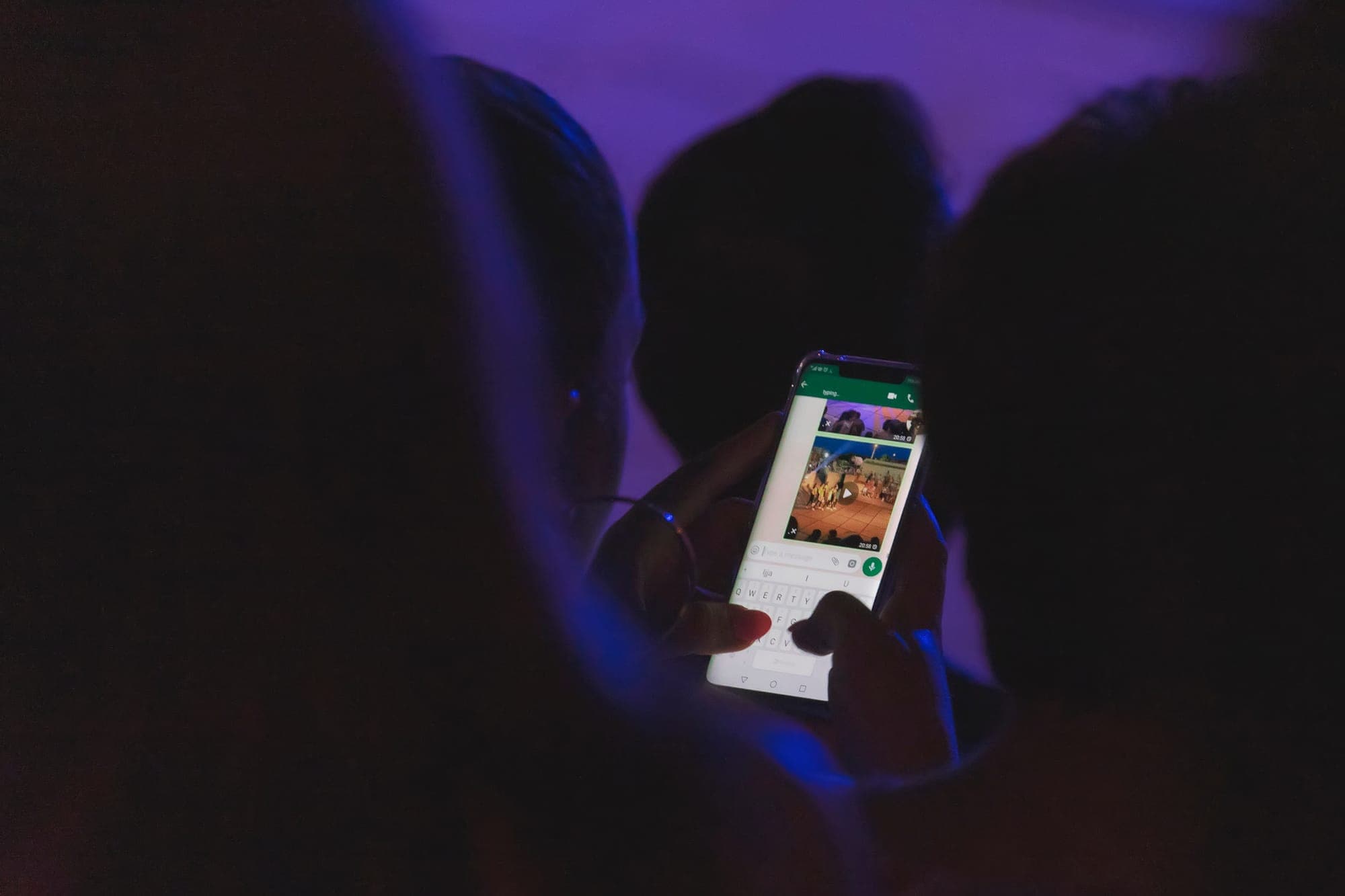 Woman in a crowd typing on her phone