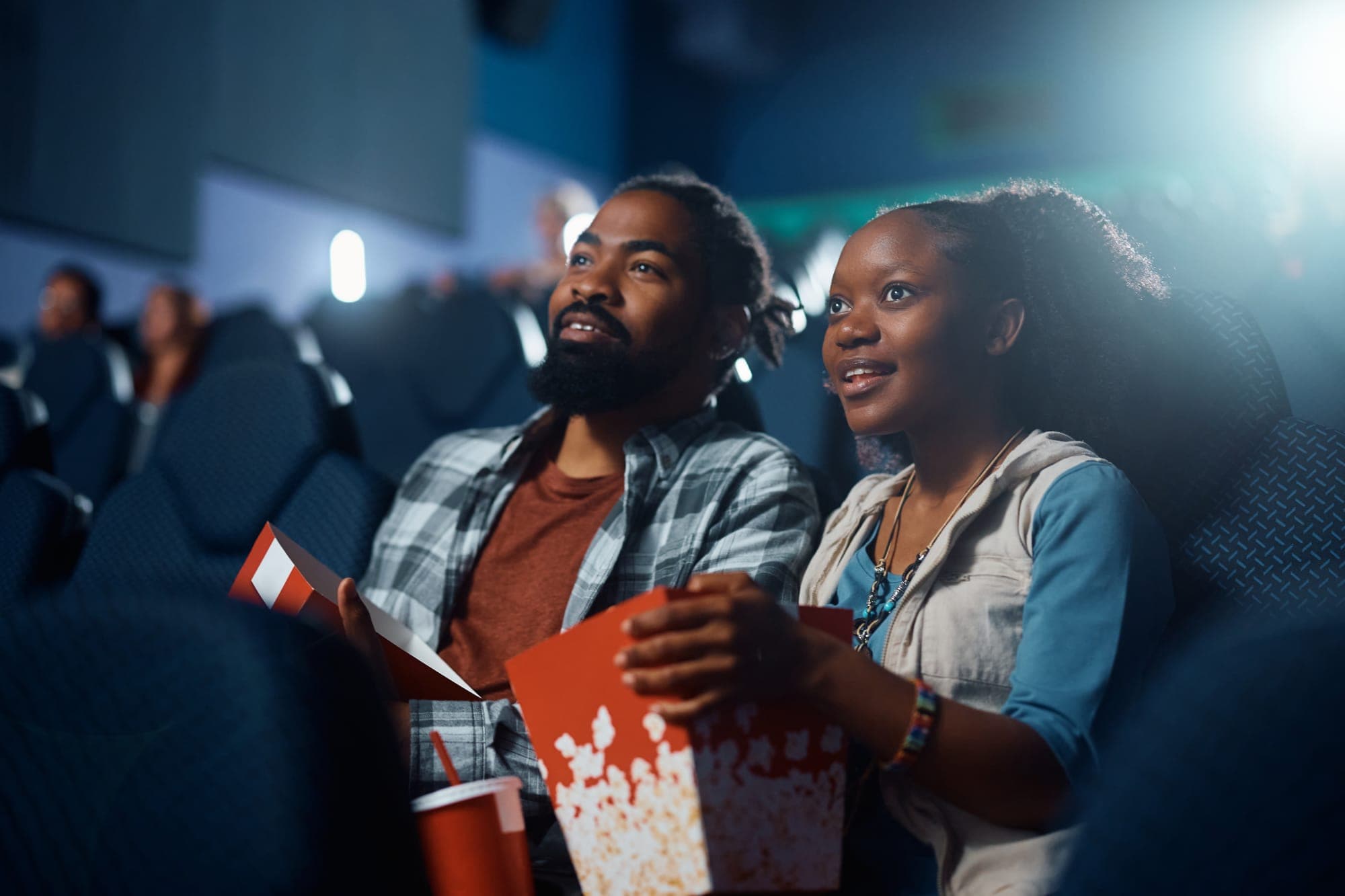 couple watching a movie together with a bucket of popcorn