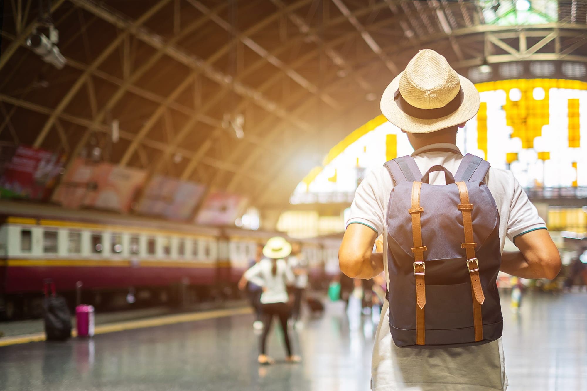 person with backpack at a train station